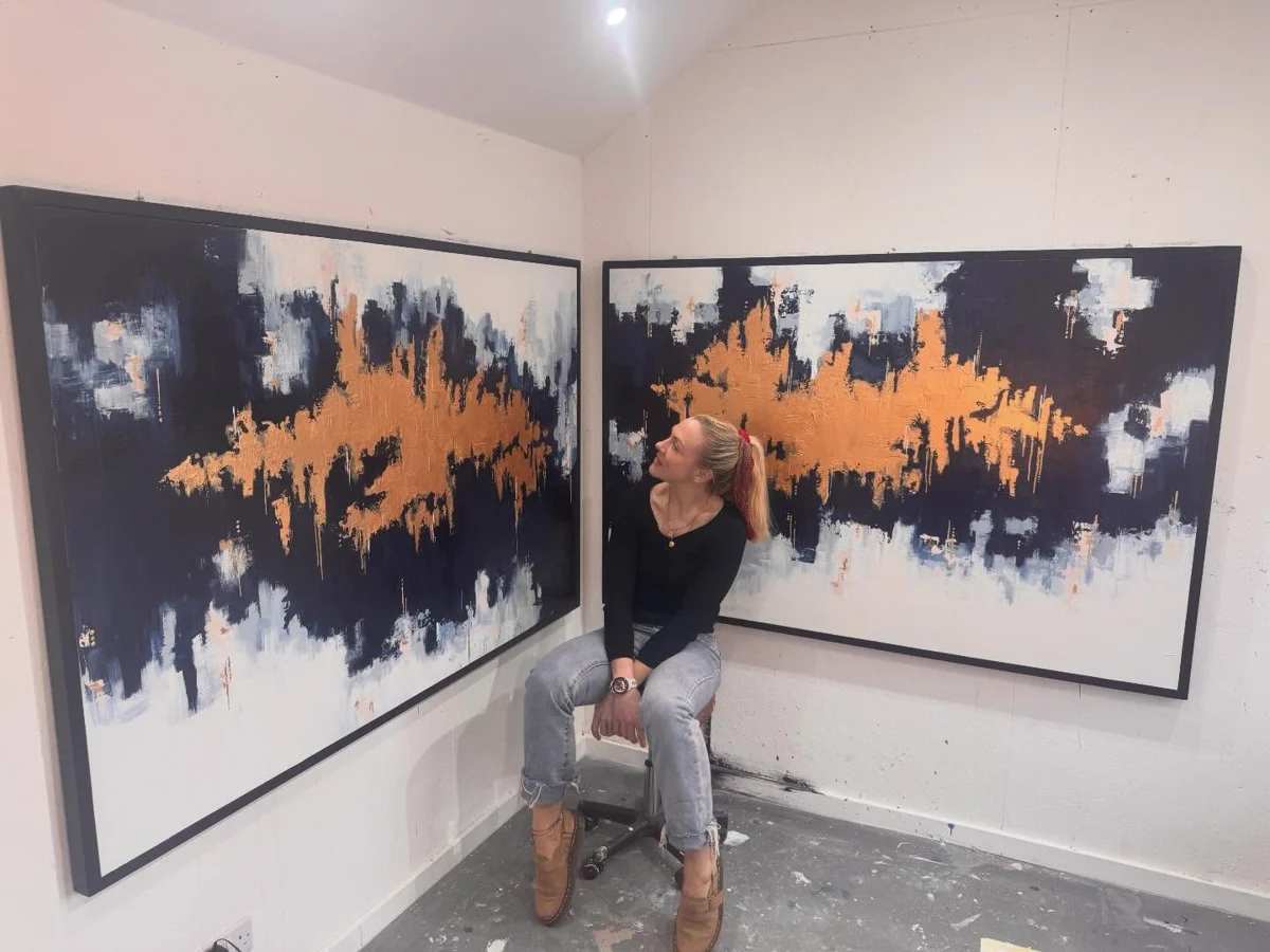 Rach in the studio with the two finished canvases